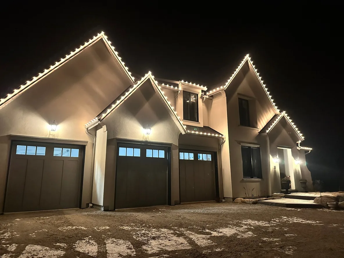 Warm white Christmas lights tracing every gable and peak of a modern home in Collingwood — a Nord install