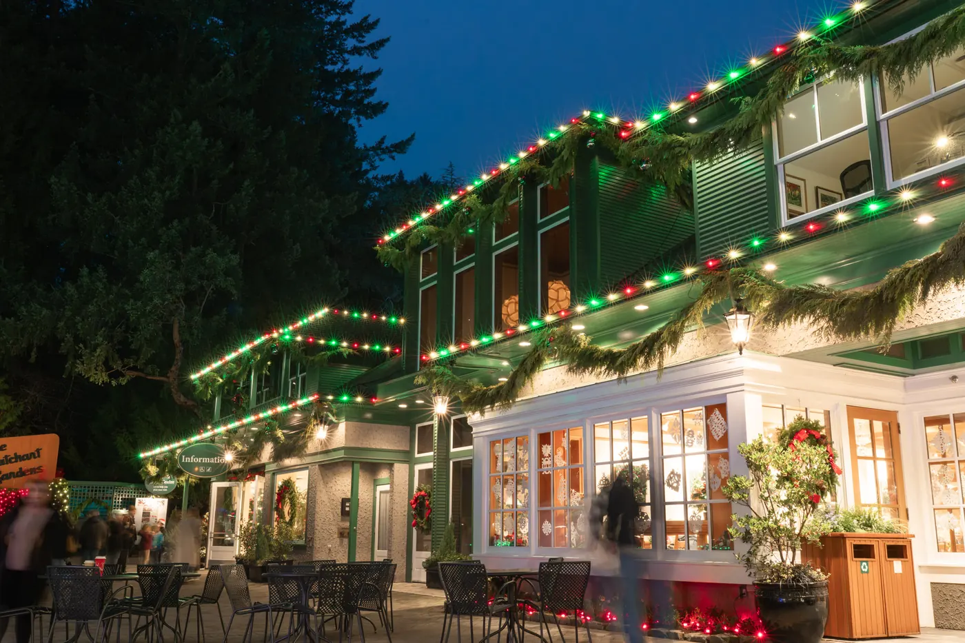 Warm-white, red and green roofline lighting with garland on a commercial storefront and patio