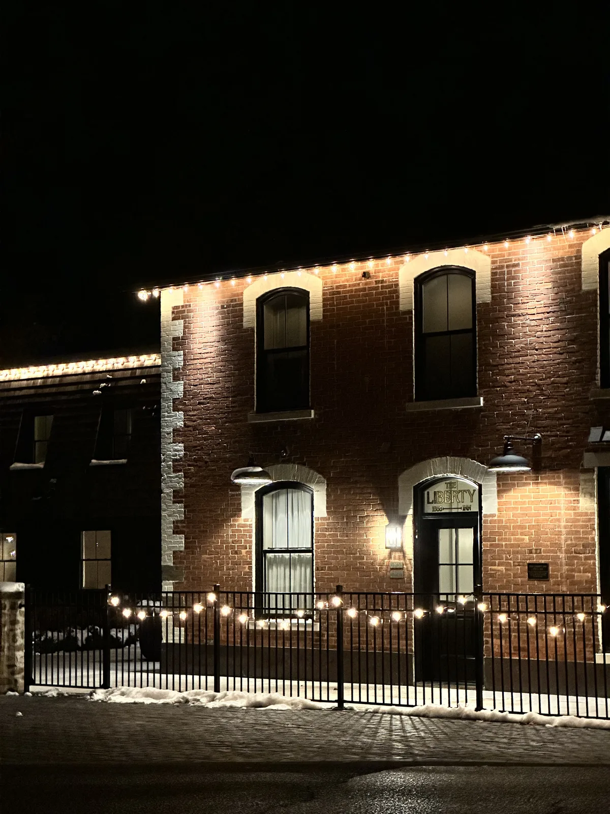 Professional Christmas light installation — The Liberty Inn · roofline, windows and the fence line