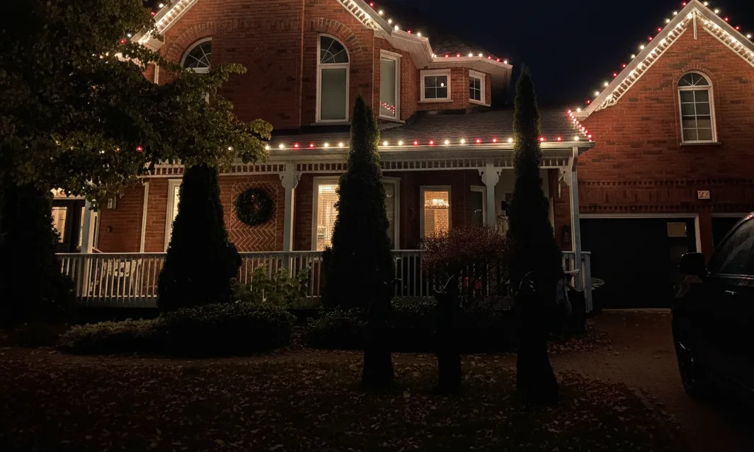 Professional Christmas light installation — Shanty Bay · red & white candy-cane on a century brick home