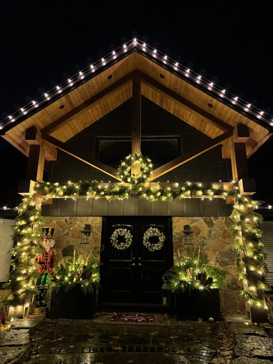 Professional Christmas light installation — Garland, wreaths & warm white on a timber-frame entrance
